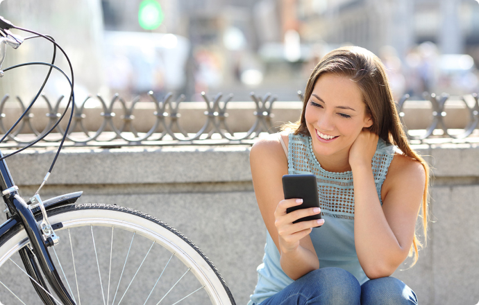 Person smiling looking at their phone in a city